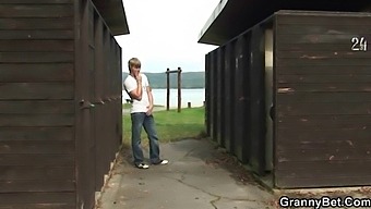 A Mature Woman Engages In Sexual Activity With A Man Near A Public Changing Room.